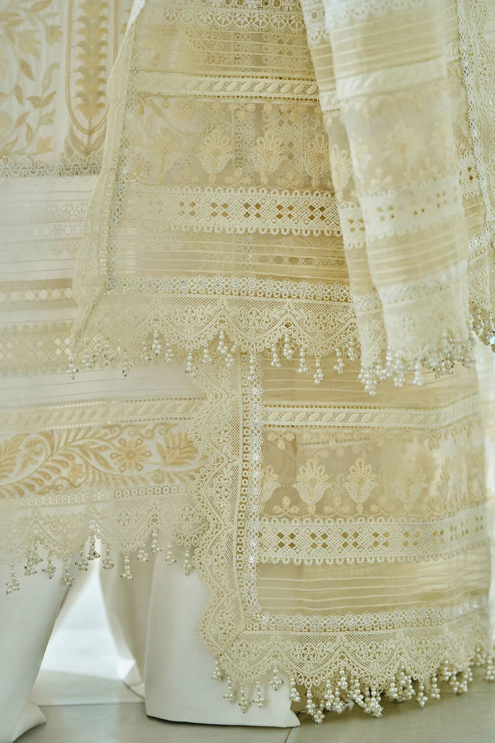 Close-up of intricately embroidered fabric on a mannequin