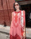 Woman wearing a red and white floral dress with sunglasses on a street.