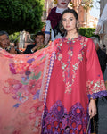 Woman in a colorful embroidered dress with a blurred outdoor background