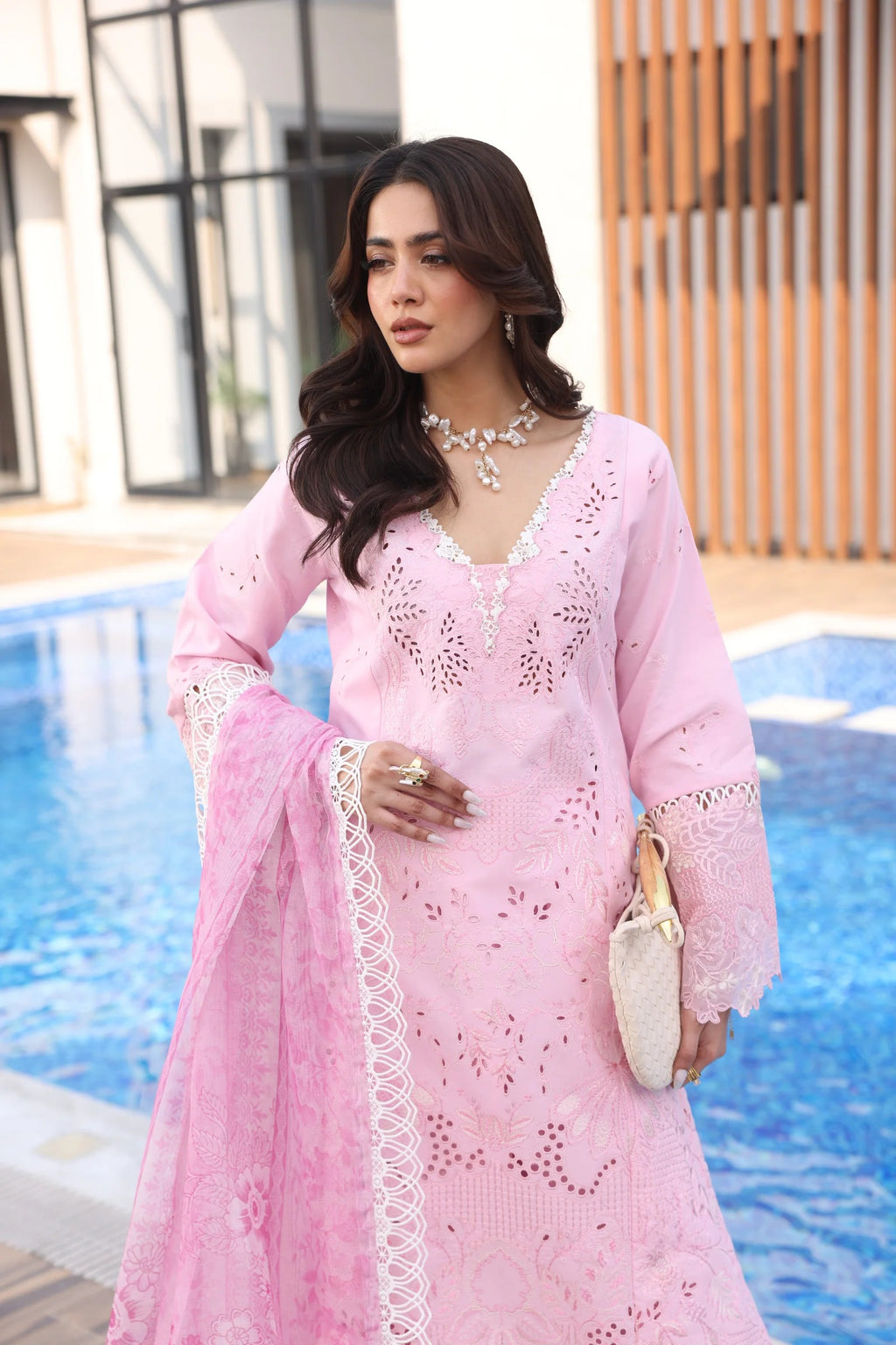 Woman in a pink traditional outfit by a pool