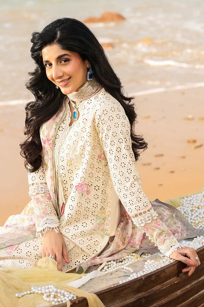 Woman in a traditional outfit with floral patterns sitting on a wooden surface.