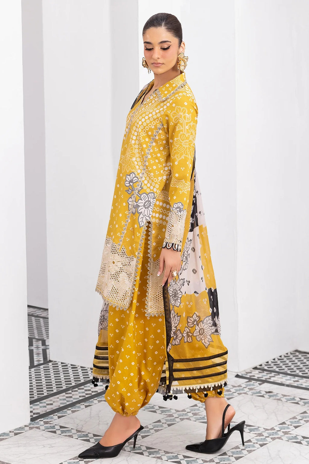 Woman wearing a yellow and black traditional outfit with a white background