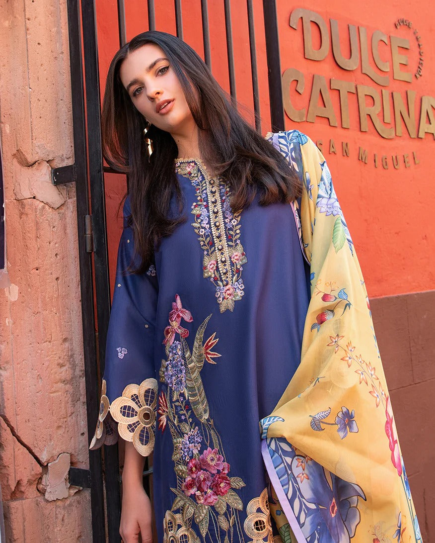 Woman wearing a colorful embroidered dress in front of a building with 'Dulce Catrina' sign.