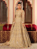 Woman in a beige embroidered traditional outfit standing in an ornate indoor setting.