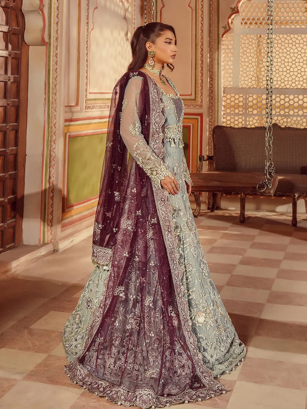 Woman in traditional embroidered outfit standing in an ornate room.