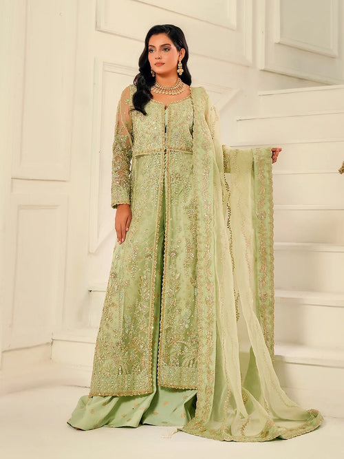Woman wearing a light green embroidered traditional outfit with a white background