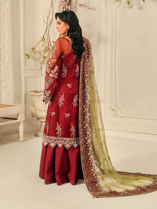 Woman in a red embroidered outfit with a matching dupatta in a decorative setting