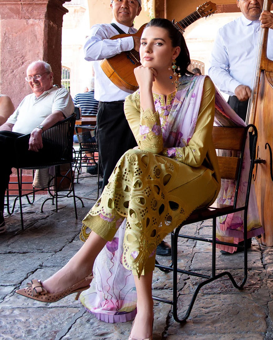 Woman in a yellow dress sitting outdoors with musicians in the background