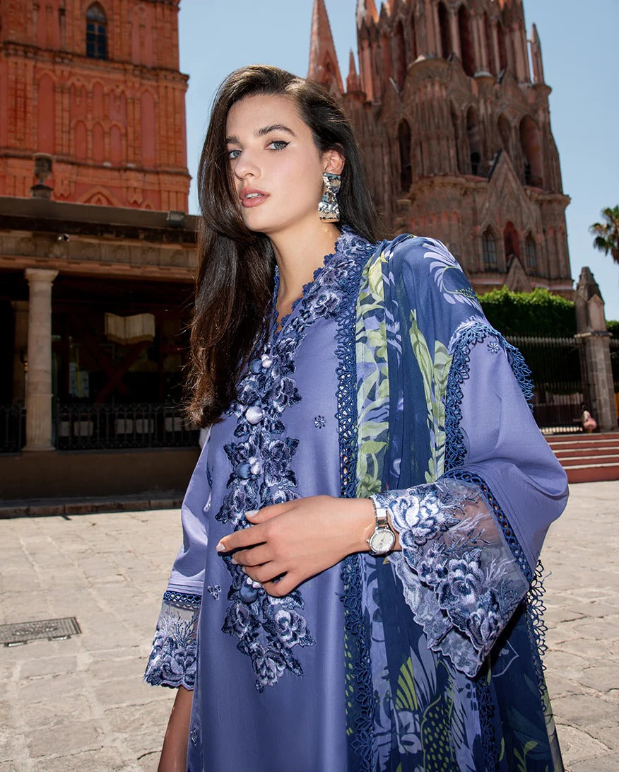 Woman in a blue embroidered outfit standing in front of a cathedral.