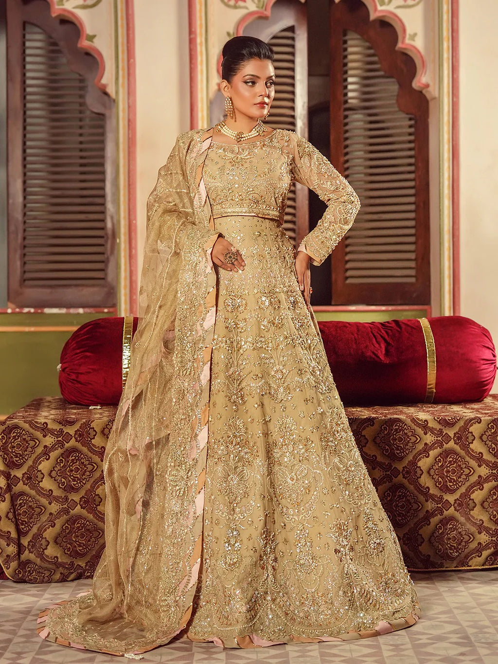 Woman in a traditional embroidered outfit standing in an ornate room.