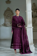 Woman in a traditional purple outfit standing in an elegant interior setting.