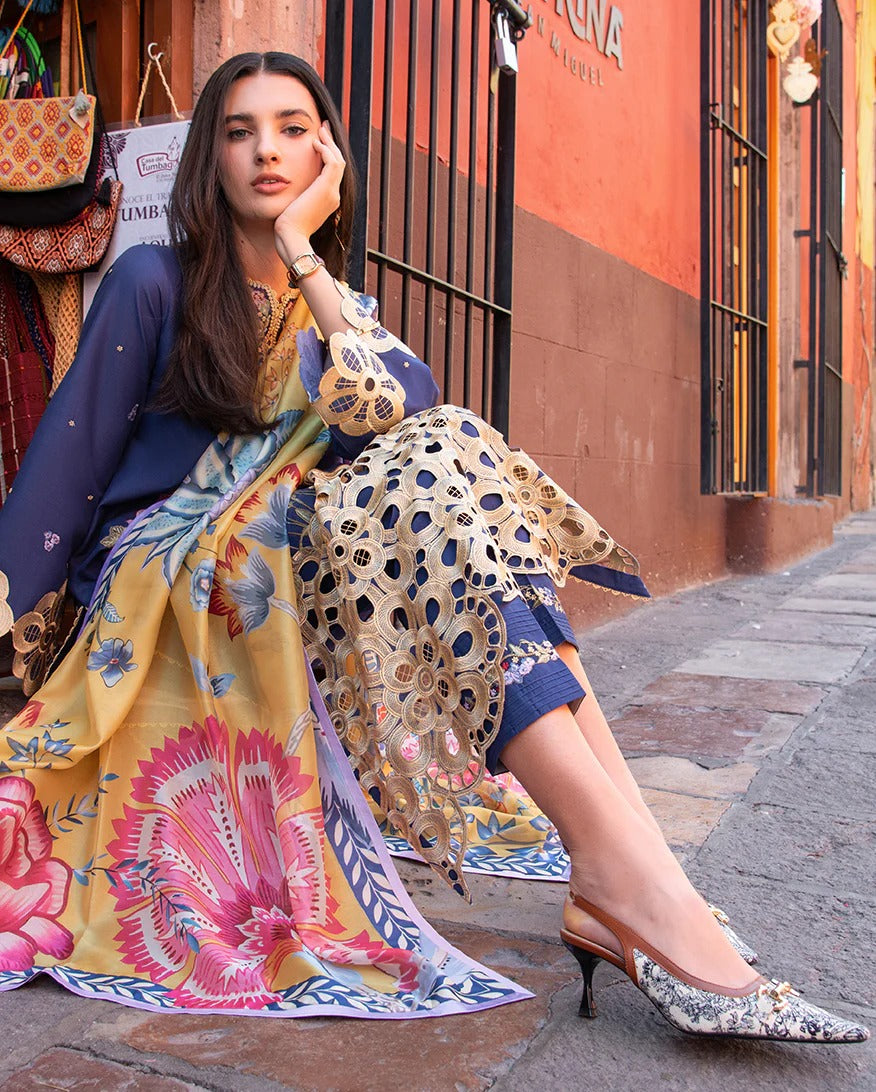 Woman in colorful traditional outfit sitting on a street corner.