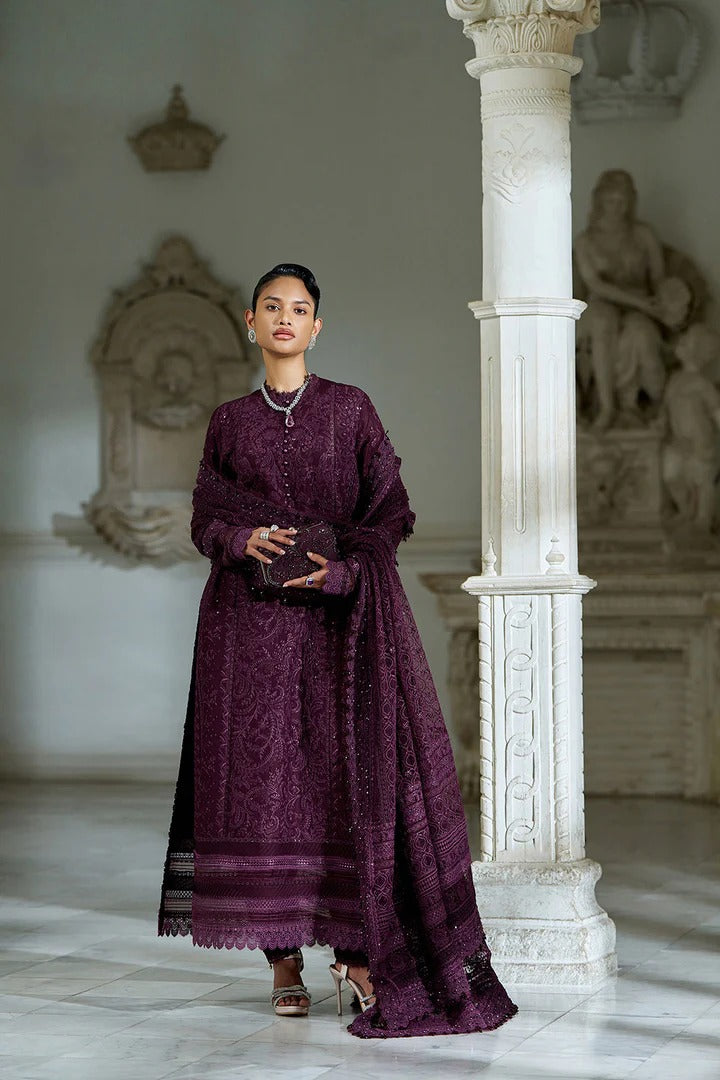 Woman in a long purple dress standing in an elegant interior setting with marble columns and sculptures.