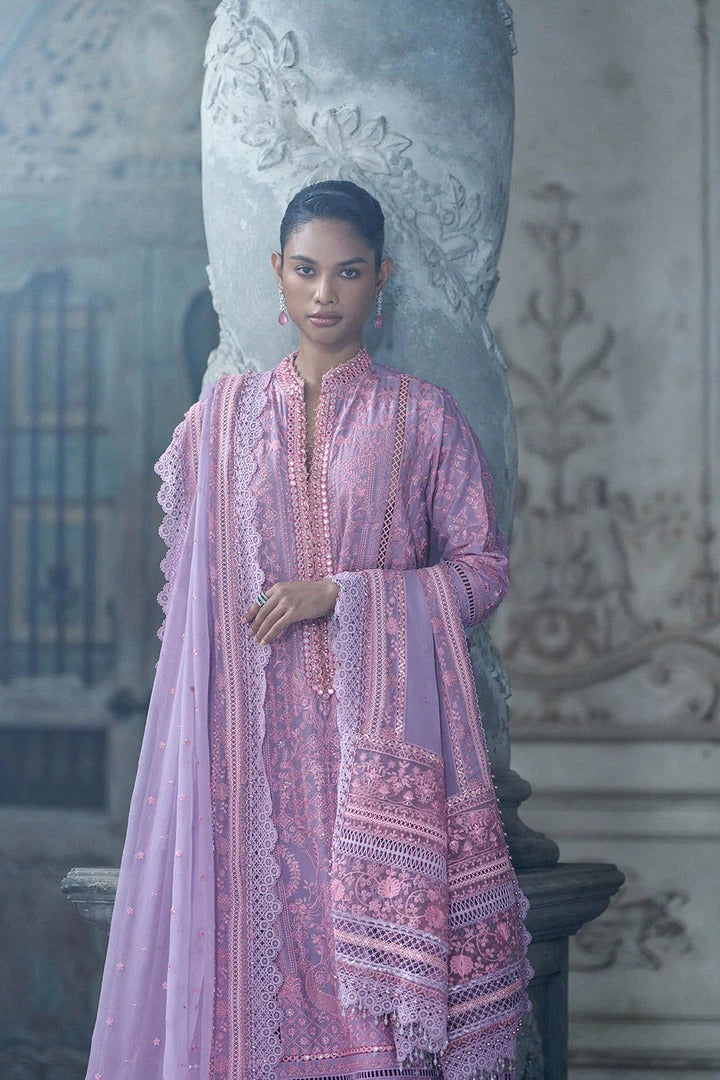 Woman in a pink traditional outfit standing in an ornate indoor setting