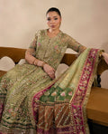 Woman in a traditional embroidered outfit sitting on a couch.