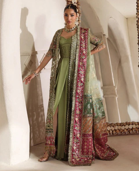 Woman in traditional green and embroidered outfit with a white background