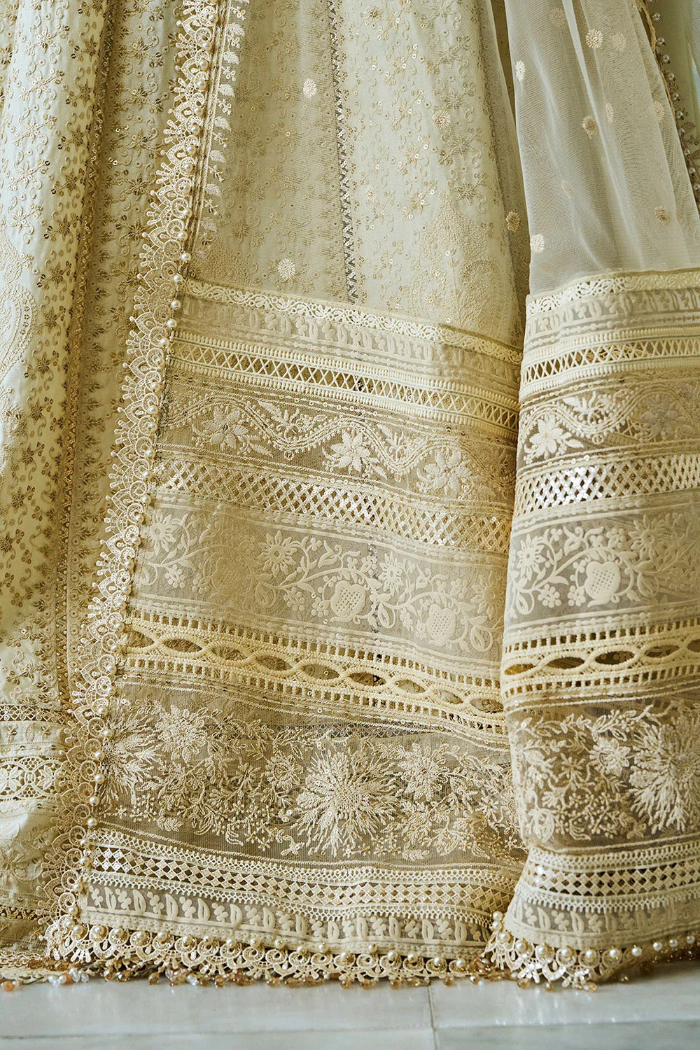 Close-up of intricately embroidered fabric with floral patterns on a neutral background