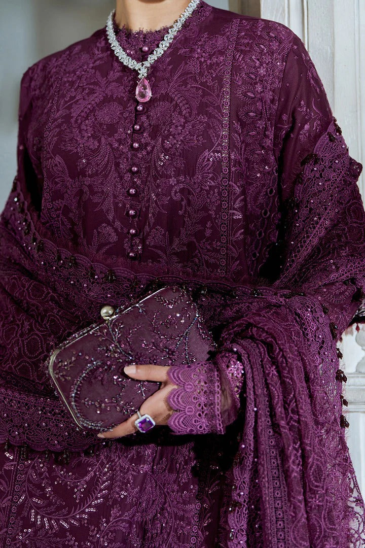 Person wearing a purple embroidered outfit holding a matching clutch.