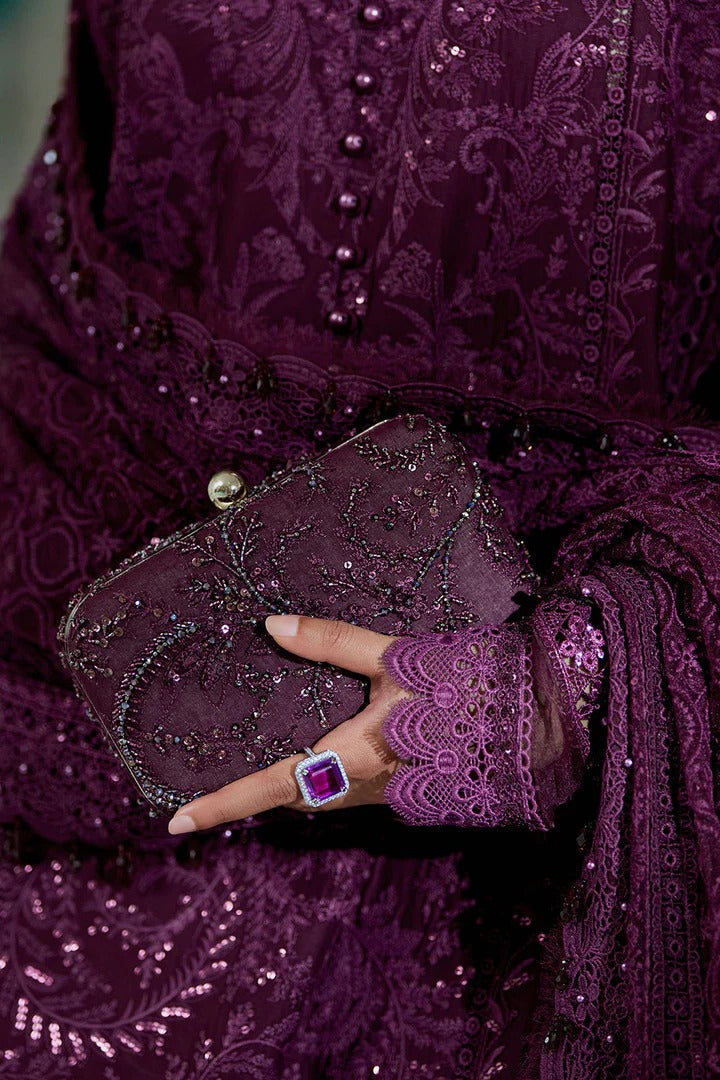 Person wearing a purple embroidered outfit holding a matching clutch.