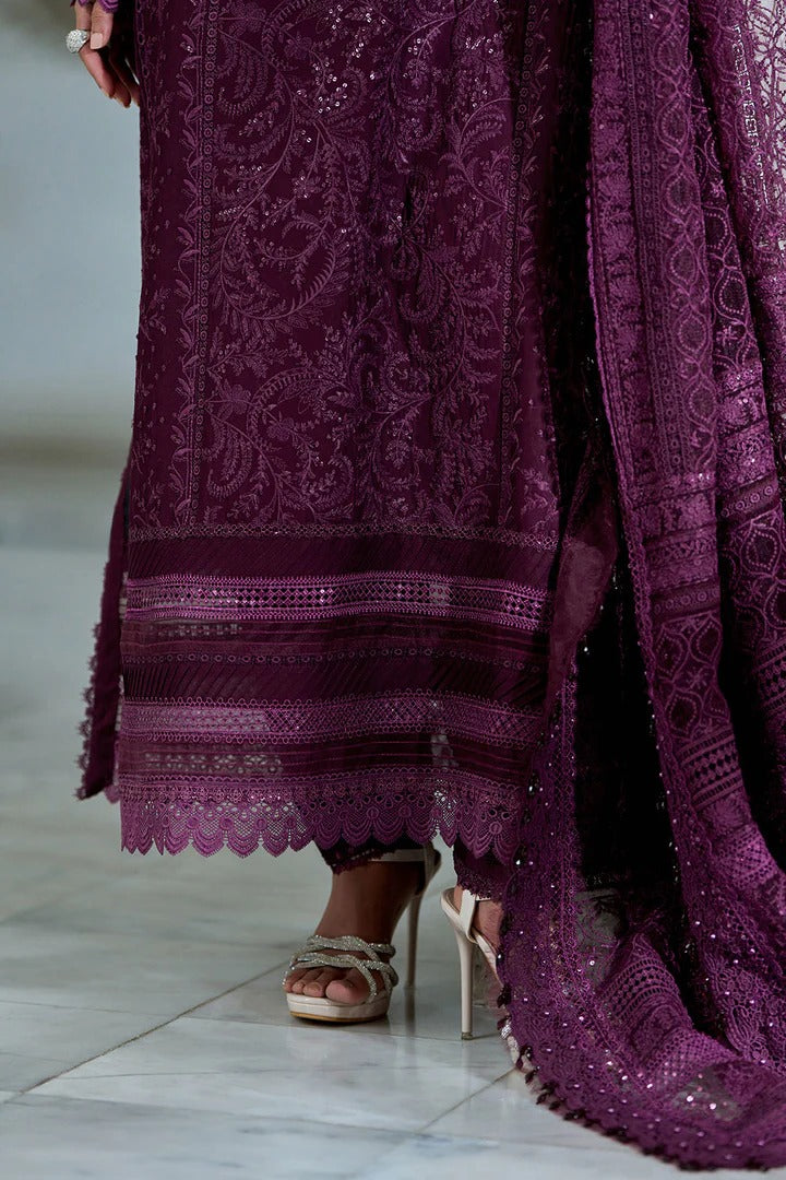 Close-up of a person wearing a purple embroidered outfit with high heels on a light background