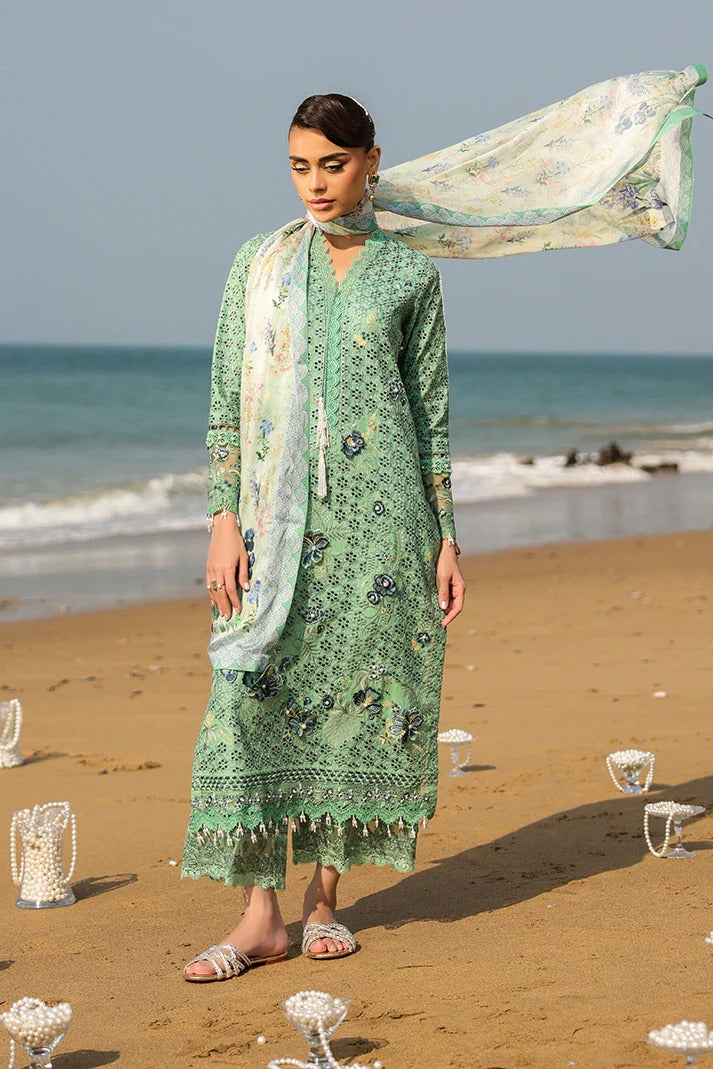 Woman in a green traditional outfit with a scarf on a beach