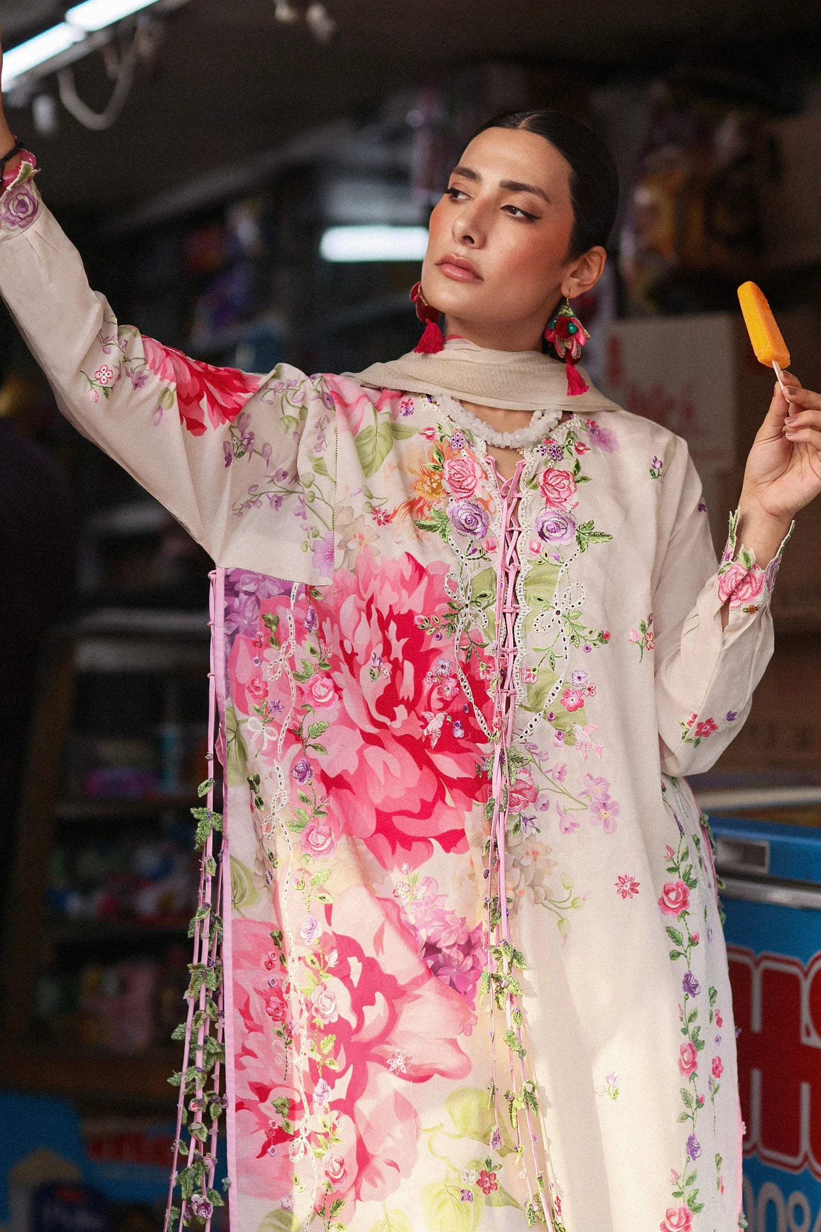 Woman in a floral dress holding a popsicle in an urban setting