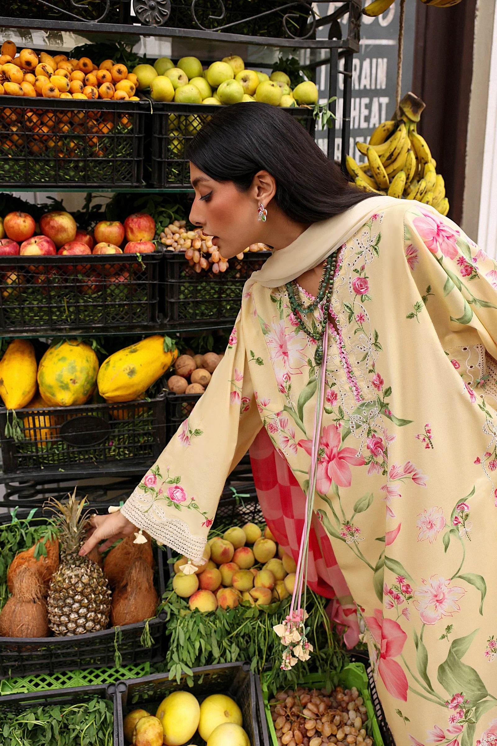 Woman shopping at a market with fruits and vegetables around her