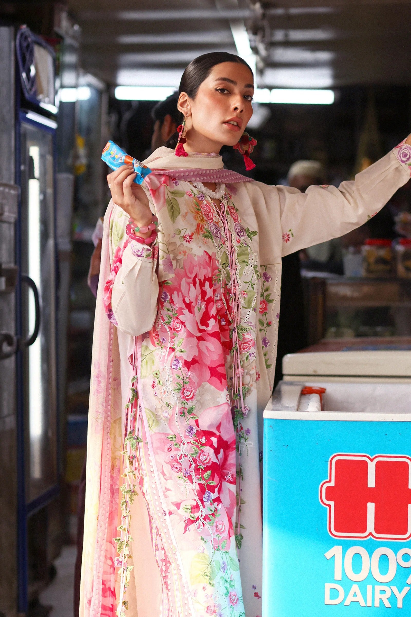 Woman in a floral dress holding a product in a store with a Hi-President dairy product display.