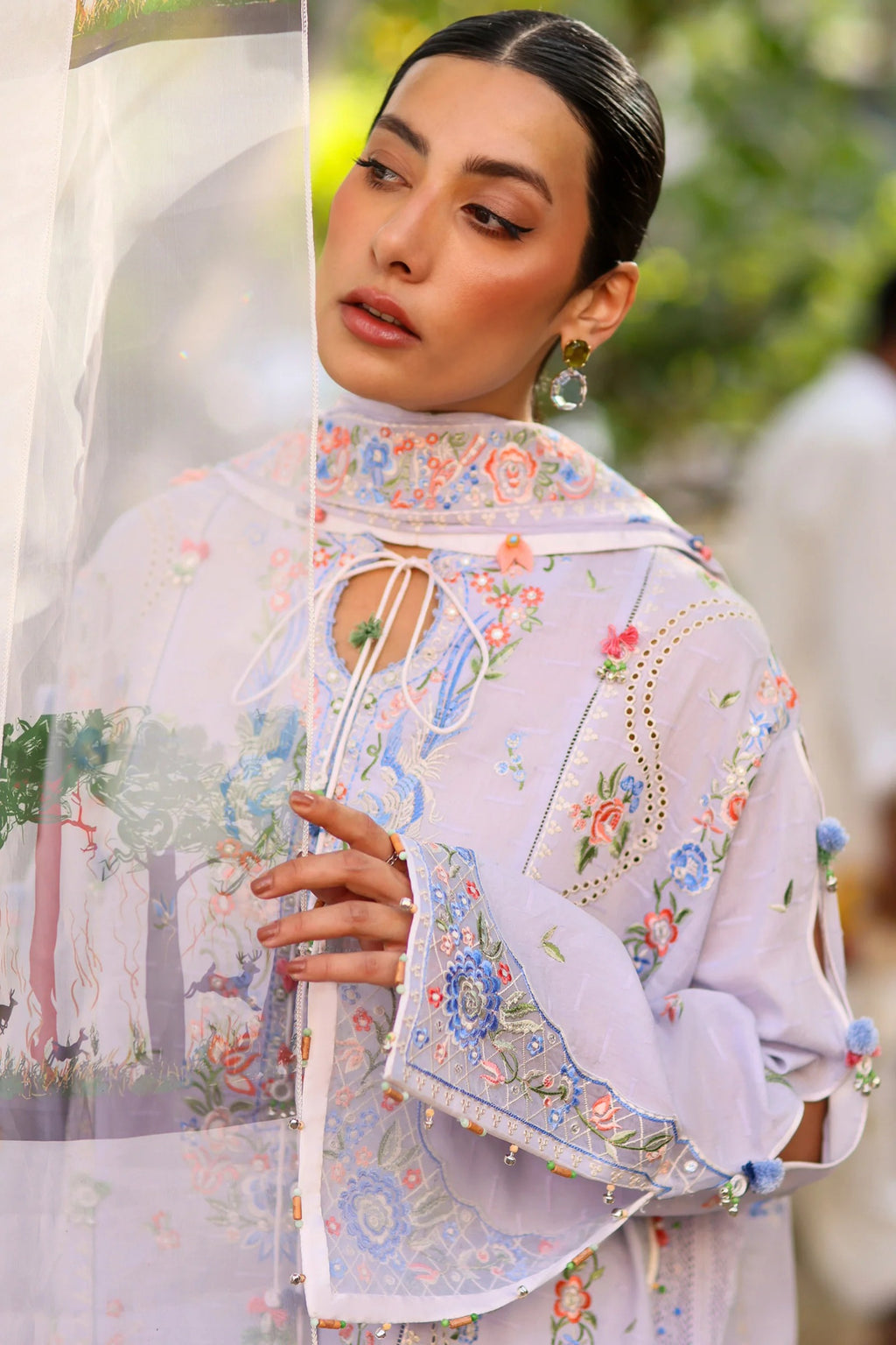 Woman wearing a traditional embroidered outfit with a blurred background
