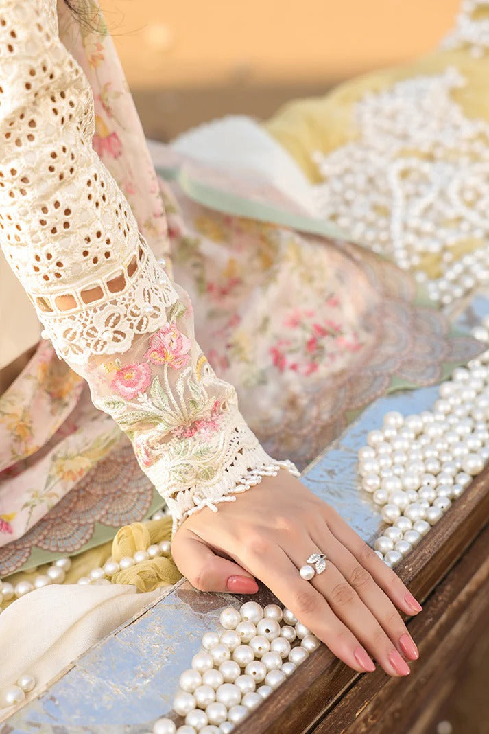 Close-up of a hand wearing a ring with a pearl bracelet on a decorative surface.