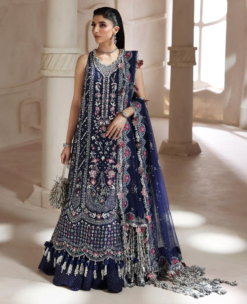 Woman wearing a traditional embroidered navy blue dress in an elegant indoor setting.