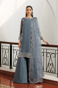 Woman wearing a gray traditional outfit with a matching dupatta in an elegant interior setting.