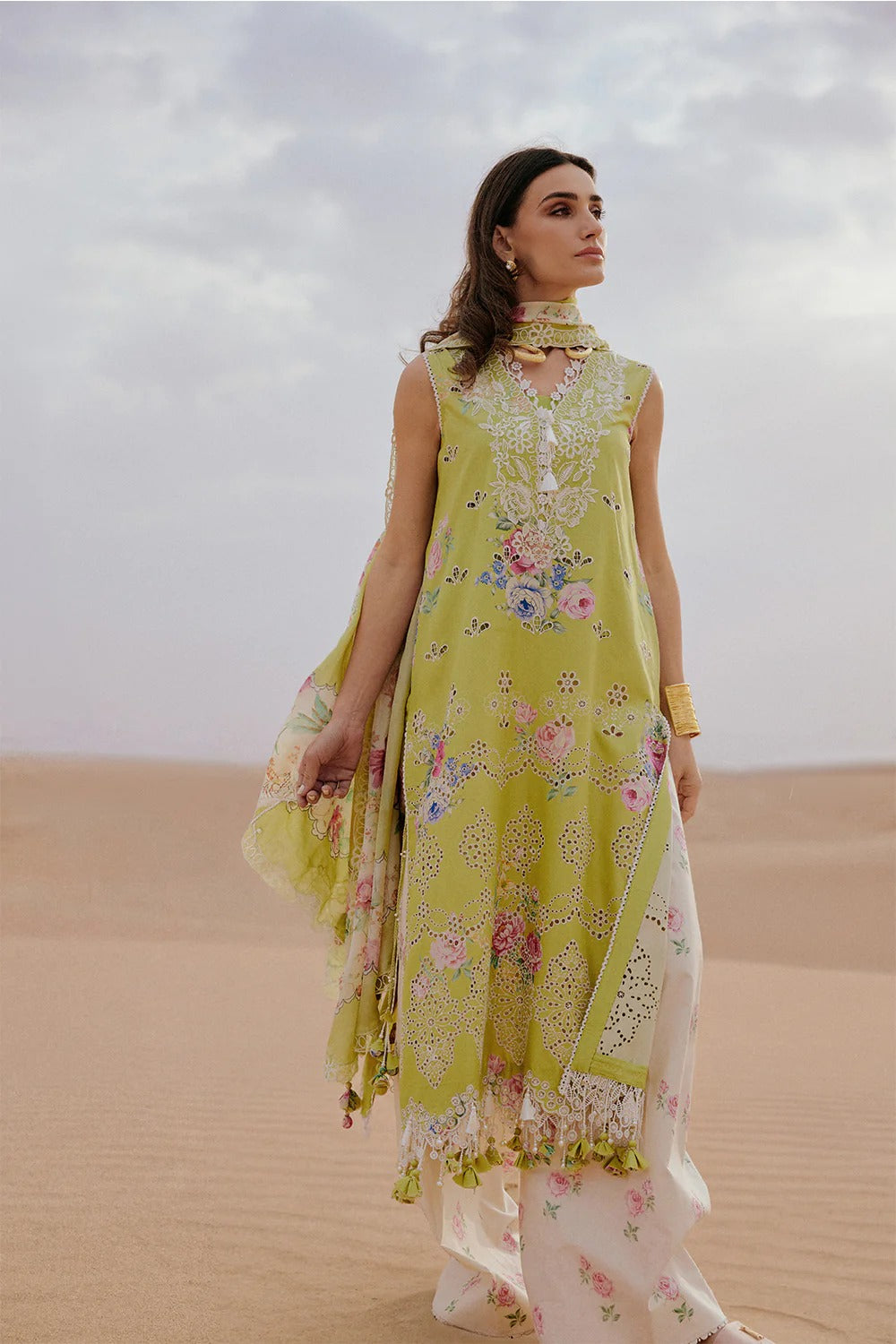 Woman in a yellow floral dress standing in a desert landscape
