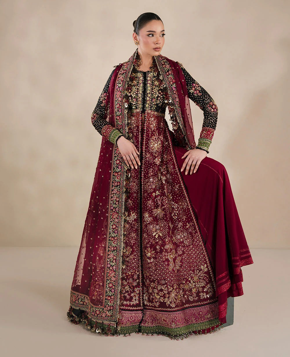 Woman wearing a traditional maroon embroidered outfit on a beige background