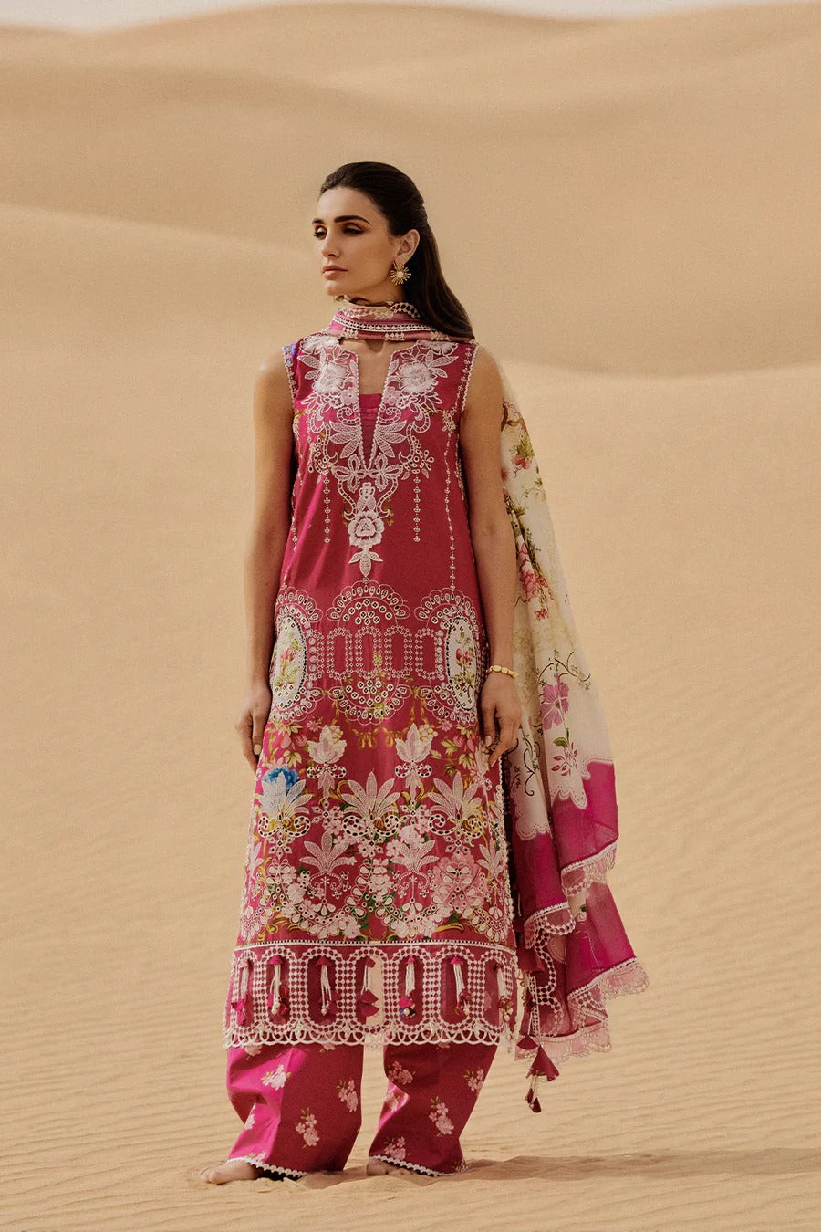 Woman in a traditional outfit standing in sand dunes
