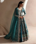 Woman wearing a traditional outfit with a blue dupatta against a neutral background