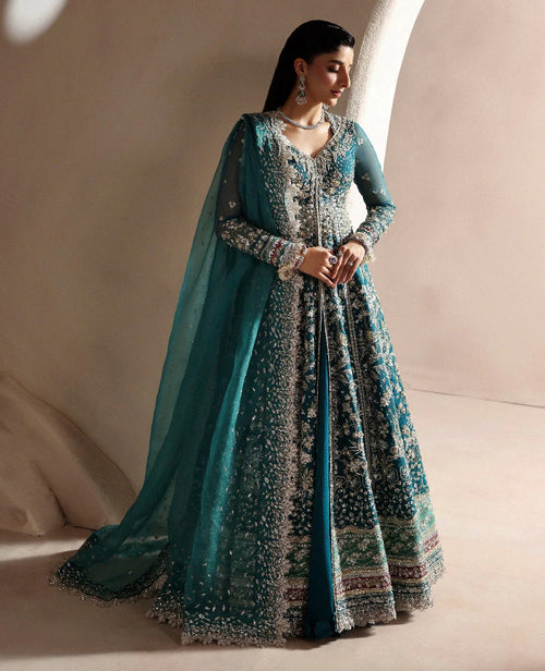 Woman wearing a traditional outfit with a blue dupatta against a neutral background