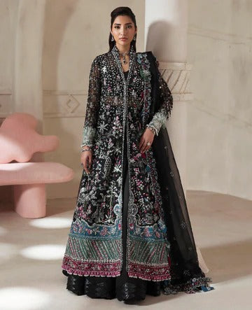 Woman wearing a traditional embroidered outfit in a minimalistic room.