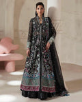 Woman wearing a traditional embroidered outfit in a minimalistic room.