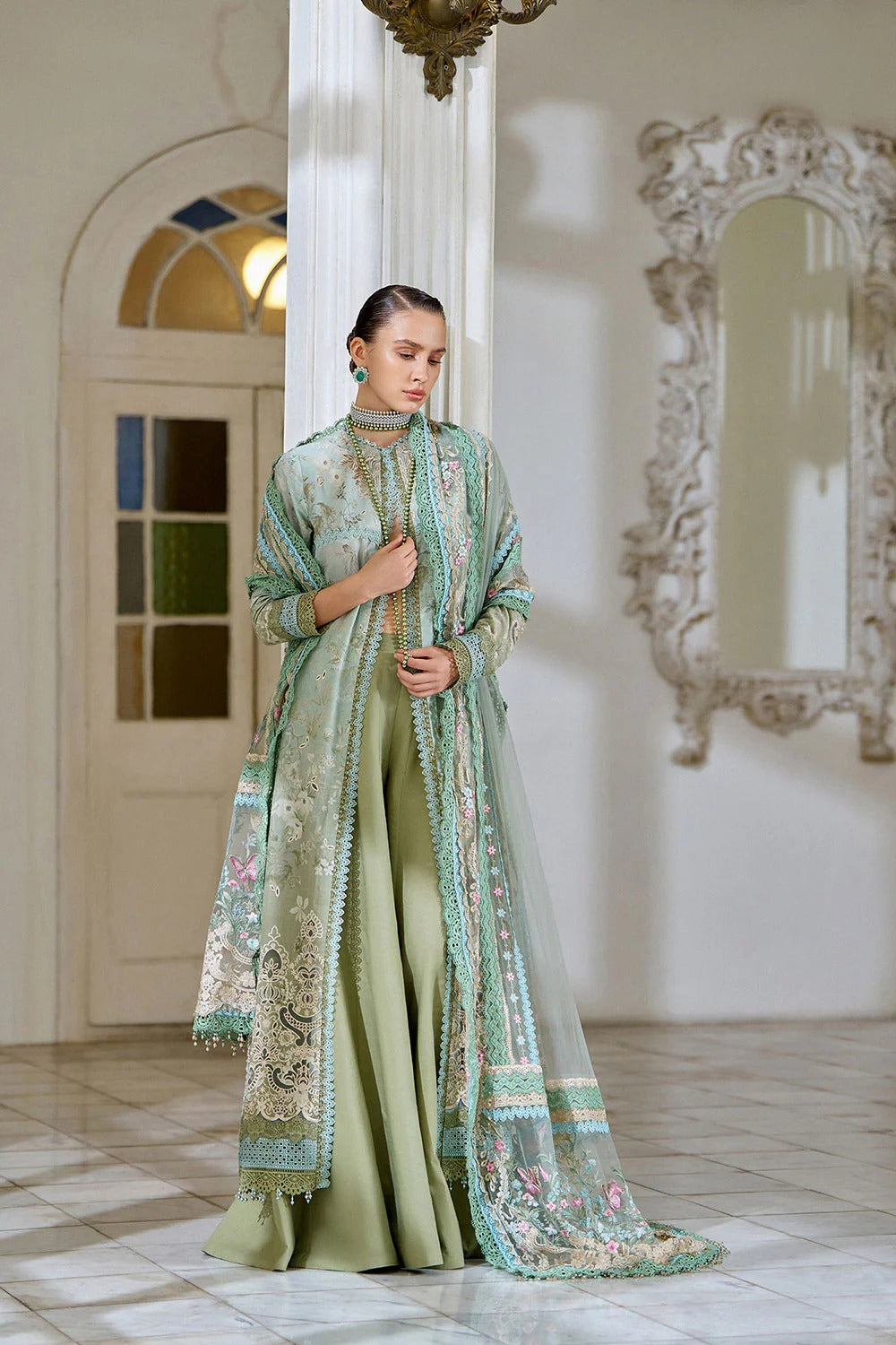 Woman in a traditional outfit standing in a room with decorative elements.