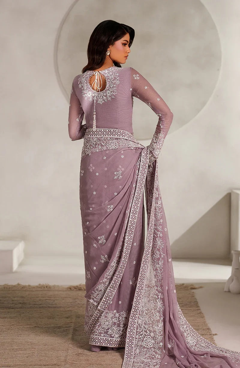 Woman wearing a lavender saree with intricate patterns in a minimalistic setting