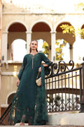 Woman in a teal dress standing in front of an architectural building.
