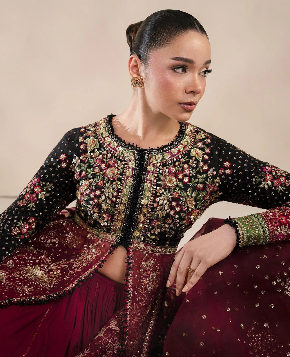 Woman wearing an ornate traditional outfit with intricate designs.
