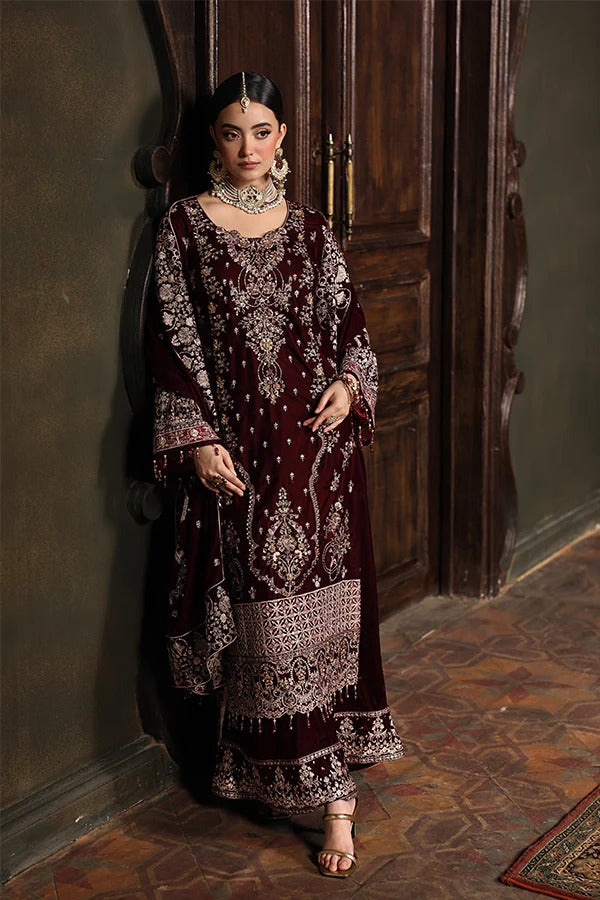 Woman in a dark red and white patterned dress standing in a room with wooden paneling.