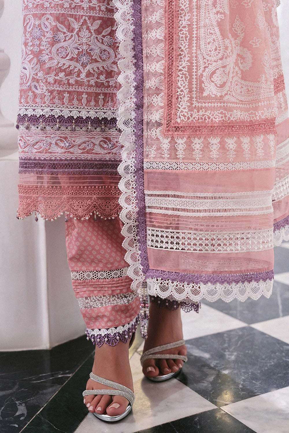 Pink embroidered outfit with white lace on a checkered floor