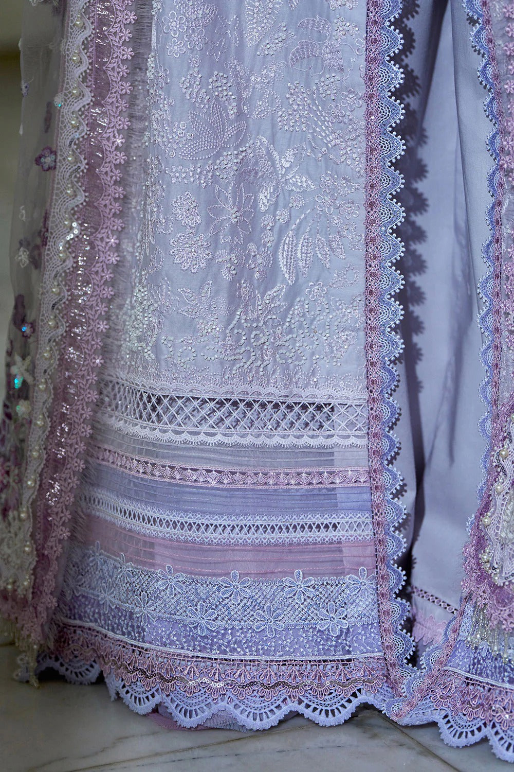 Close-up of a lace garment with intricate patterns and colorful embroidery.