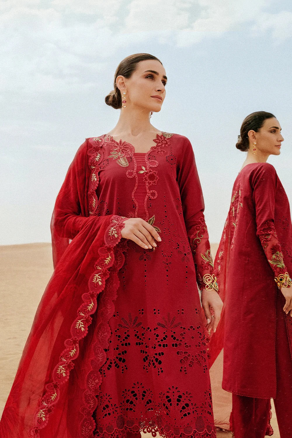 Woman wearing a red embroidered traditional outfit with a desert background