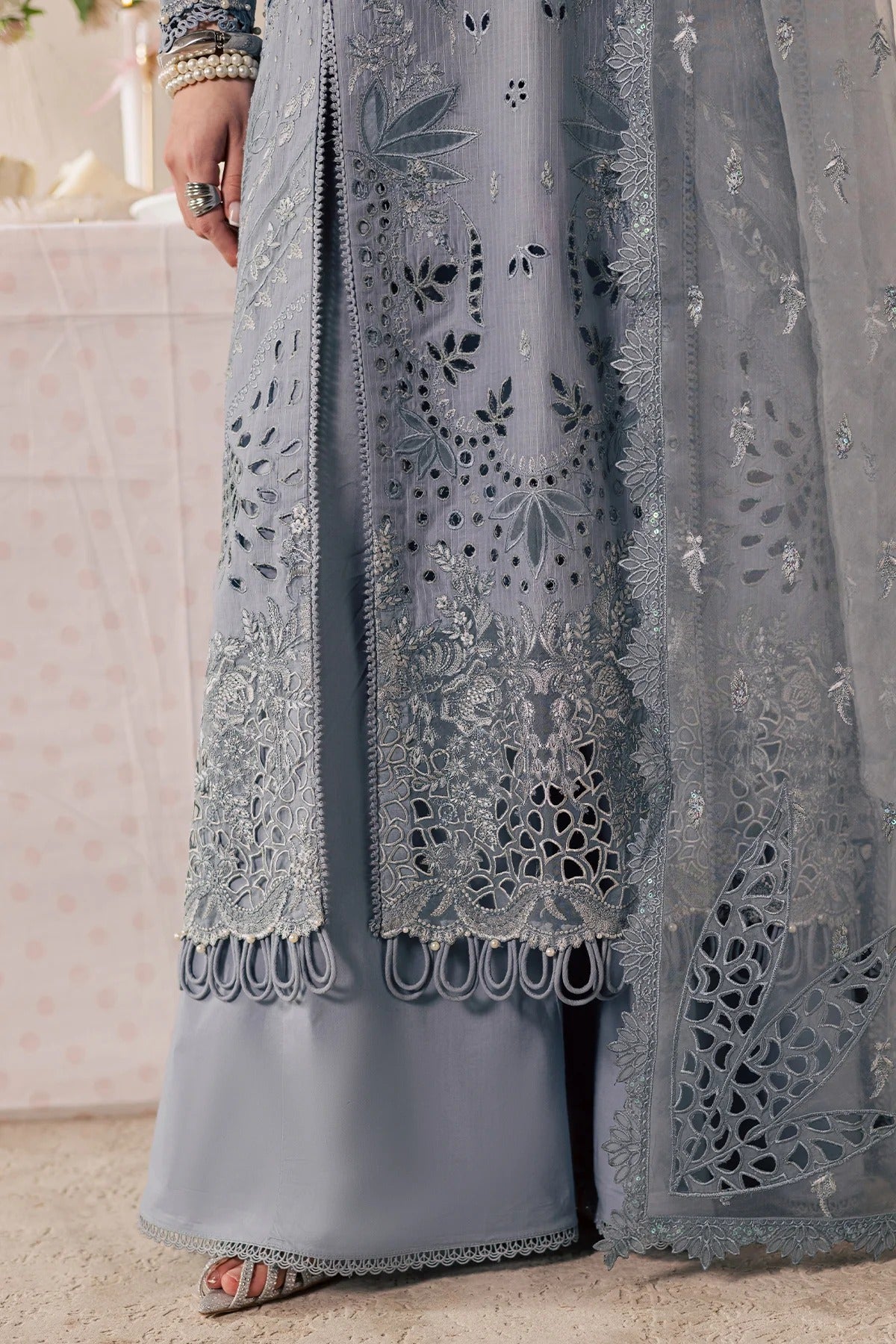 Close-up of a gray embroidered garment with intricate patterns.