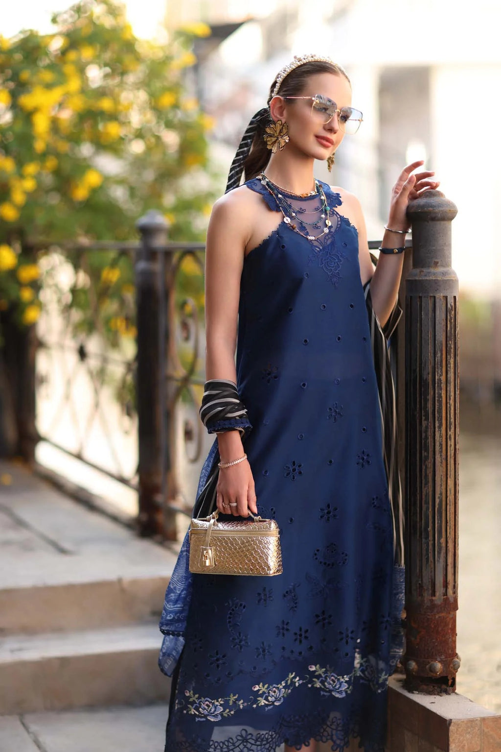 Woman in a blue dress standing outdoors with blurred background