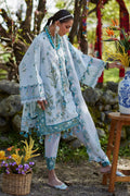 Woman in traditional outfit with floral patterns in a garden setting